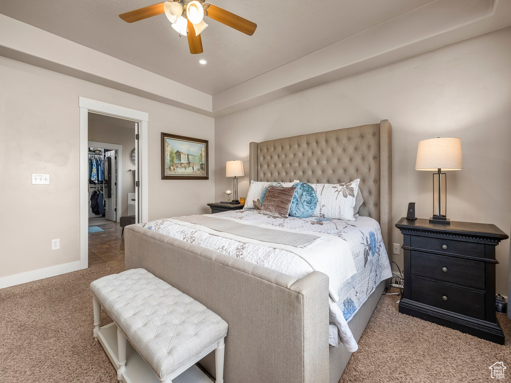 Bedroom with ceiling fan, a closet, light carpet, and a spacious closet