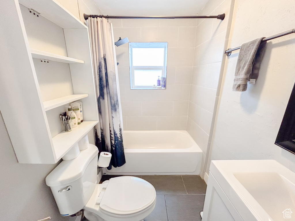Full bathroom with shower / bath combination with curtain, toilet, vanity, and tile flooring