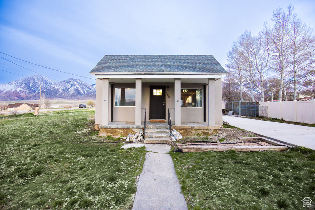 Bungalow with a mountain view, a porch, and a front lawn