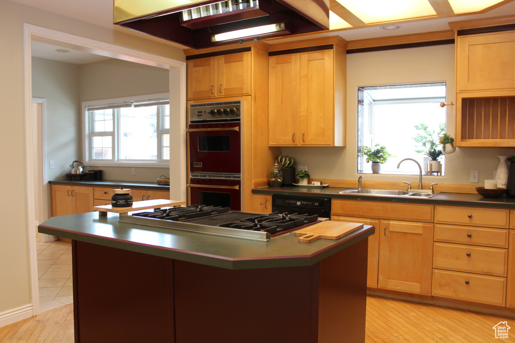 Kitchen featuring a kitchen island, gas cooktop, black double oven, dishwasher, and sink