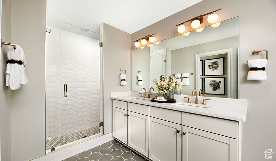 Bathroom featuring an enclosed shower, tile floors, dual sinks, and large vanity