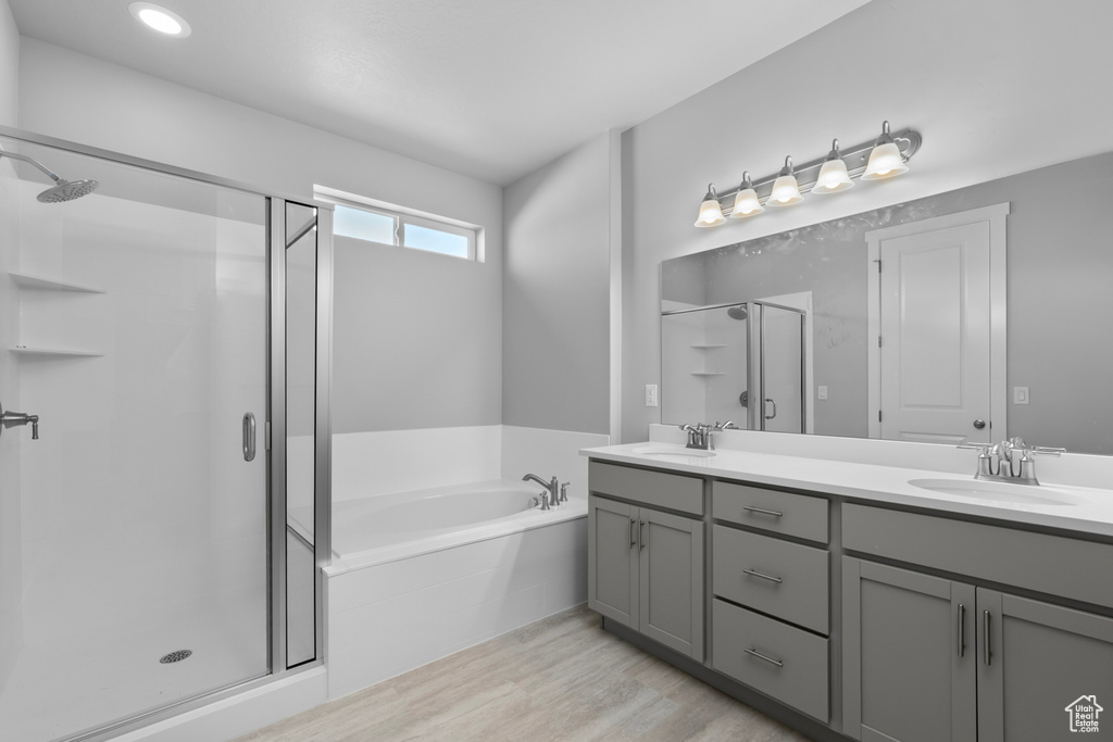 Bathroom featuring shower with separate bathtub, hardwood / wood-style flooring, and dual bowl vanity