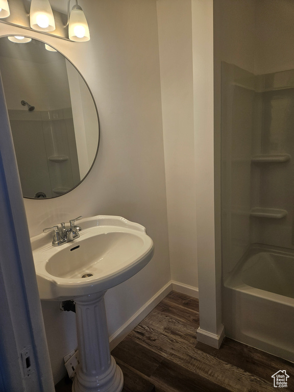 Bathroom featuring hardwood / wood-style floors and washtub / shower combination