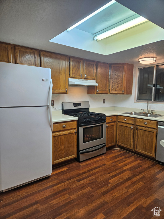 Kitchen with stainless steel appliances, sink, and dark wood-type flooring