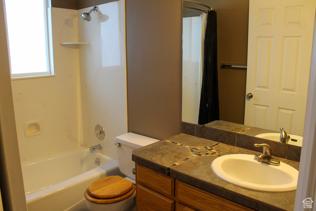 Full bathroom with shower / tub combo with curtain, toilet, and vanity