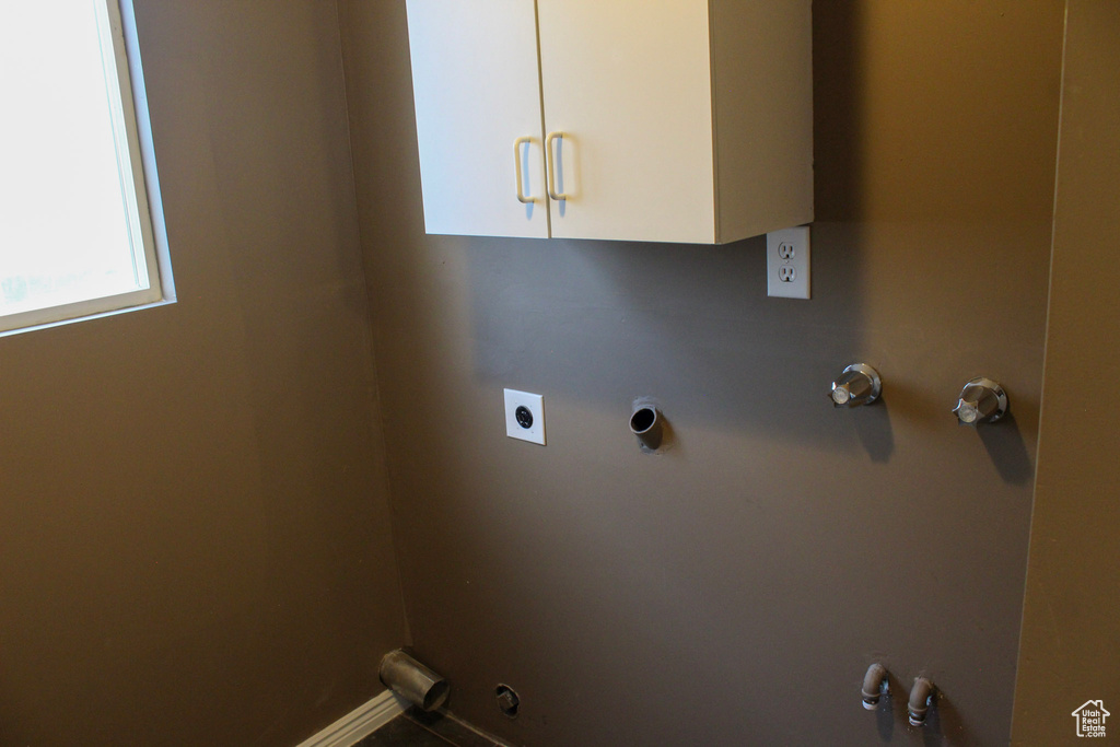 Washroom with electric dryer hookup, hookup for a gas dryer, and cabinets