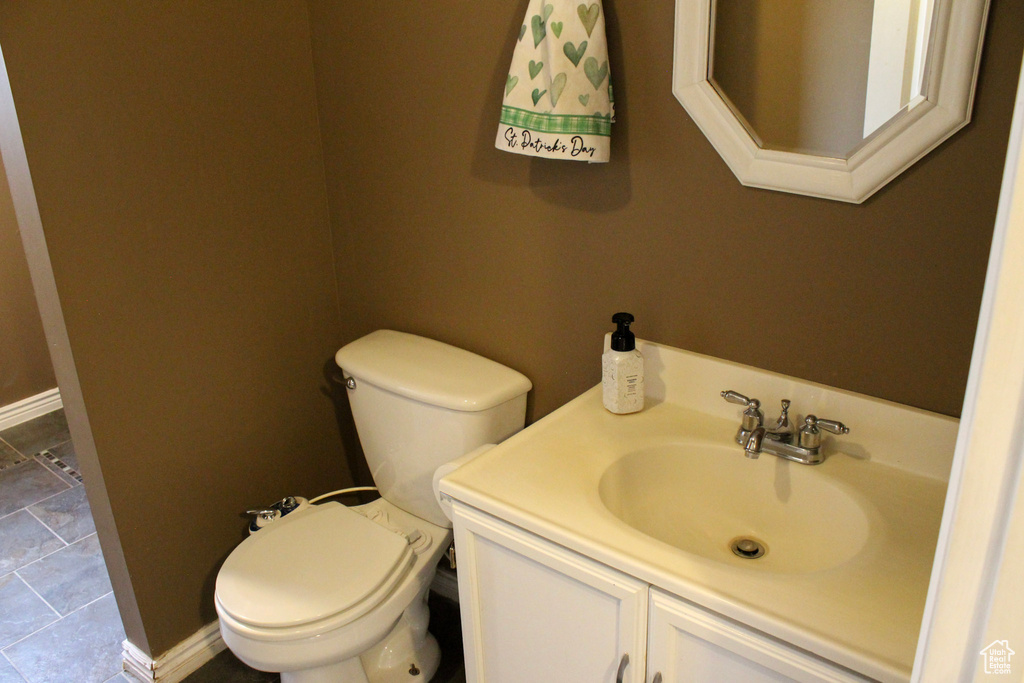 Bathroom with toilet, vanity, and tile flooring