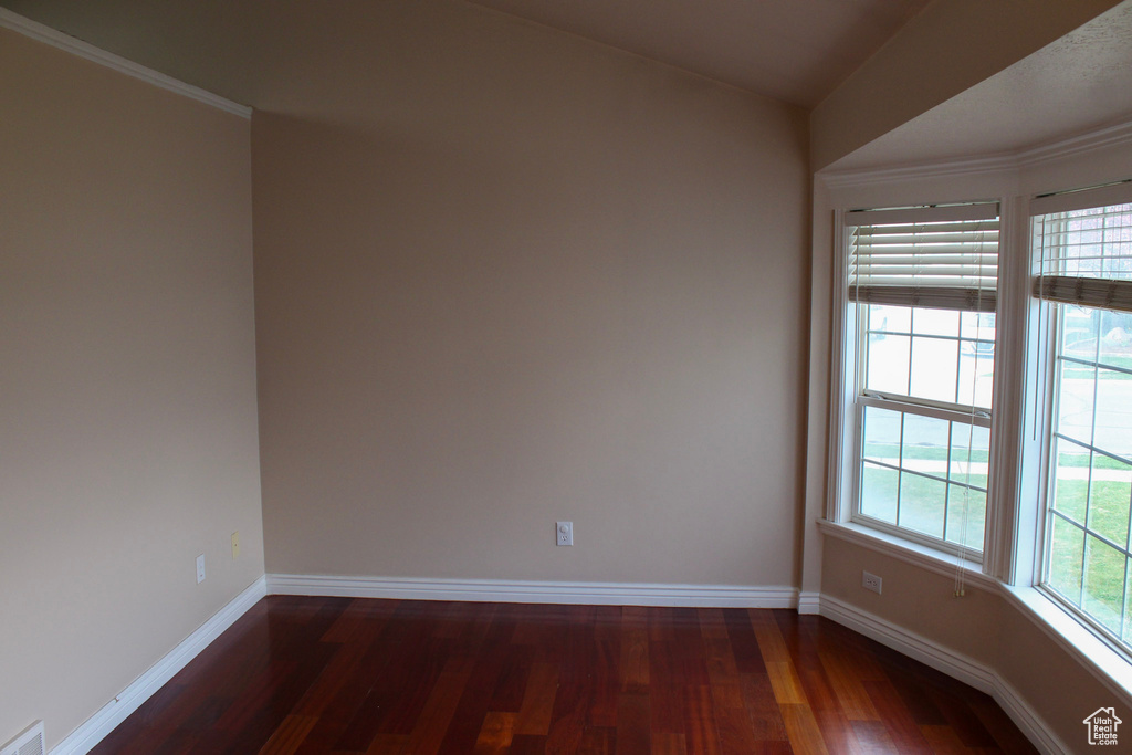 Empty room featuring dark wood-type flooring