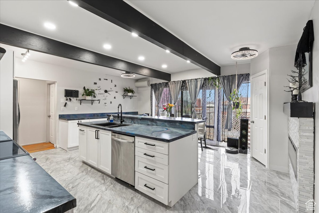 Kitchen with stainless steel dishwasher, light tile floors, a center island with sink, white cabinetry, and sink