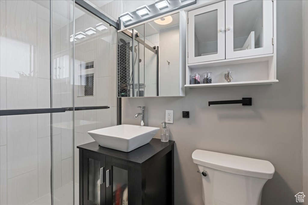 Bathroom with an enclosed shower, vanity, and toilet