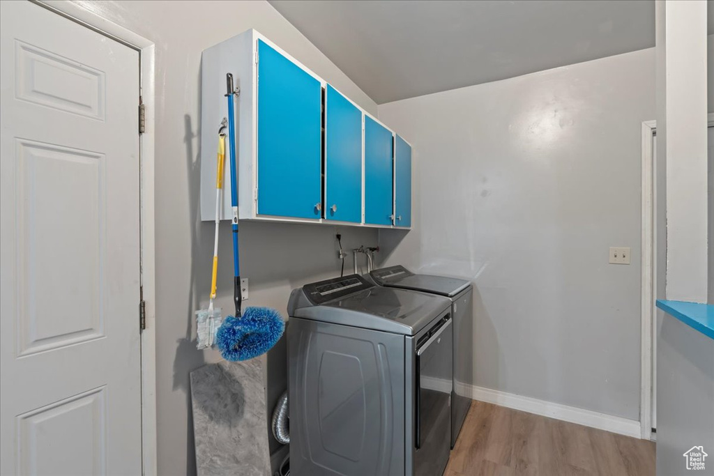 Laundry area with light hardwood / wood-style floors, cabinets, independent washer and dryer, and hookup for a washing machine