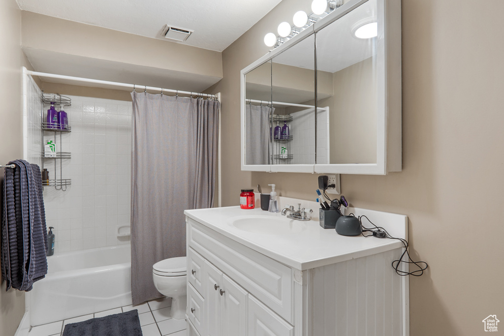 Full bathroom featuring shower / bath combination with curtain, tile flooring, large vanity, and toilet