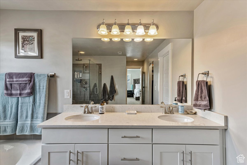 Bathroom featuring double sink vanity and separate shower and tub
