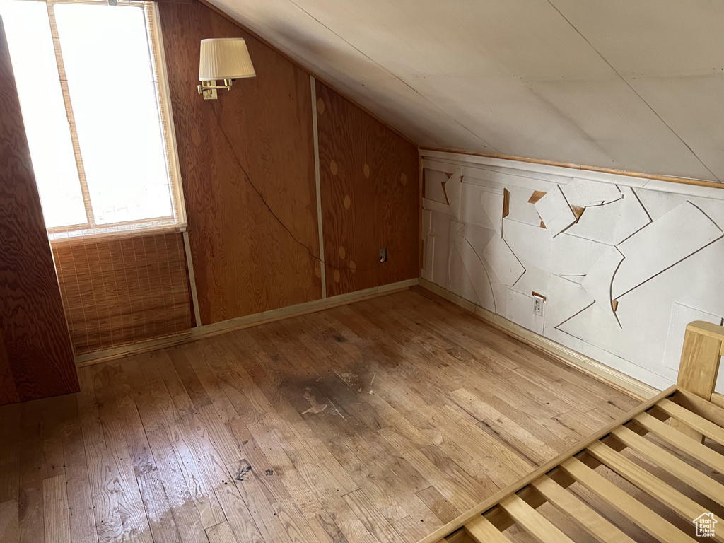 Bonus room with lofted ceiling and light hardwood / wood-style flooring