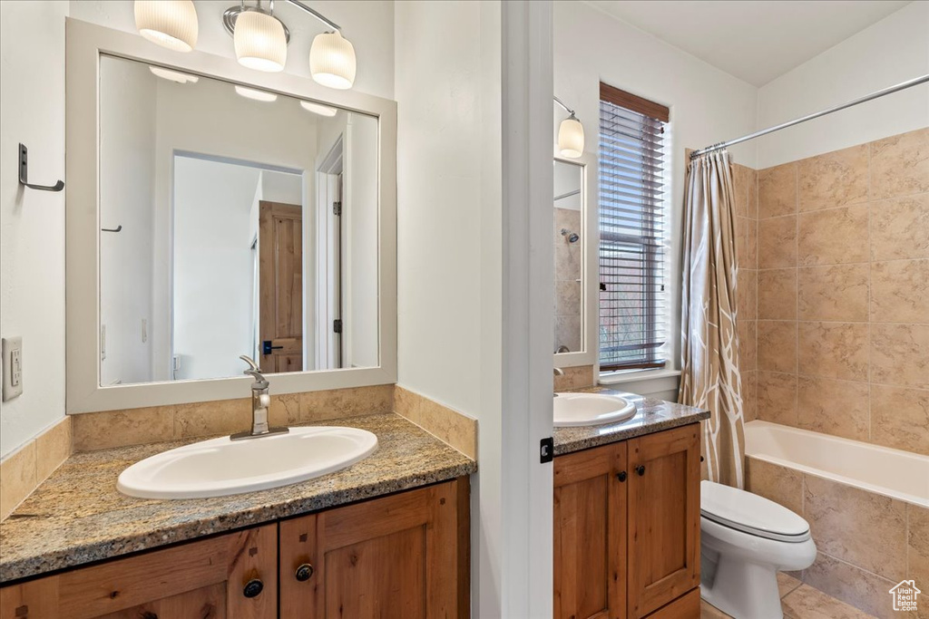 Full bathroom featuring shower / bath combination with curtain, tile floors, toilet, and vanity