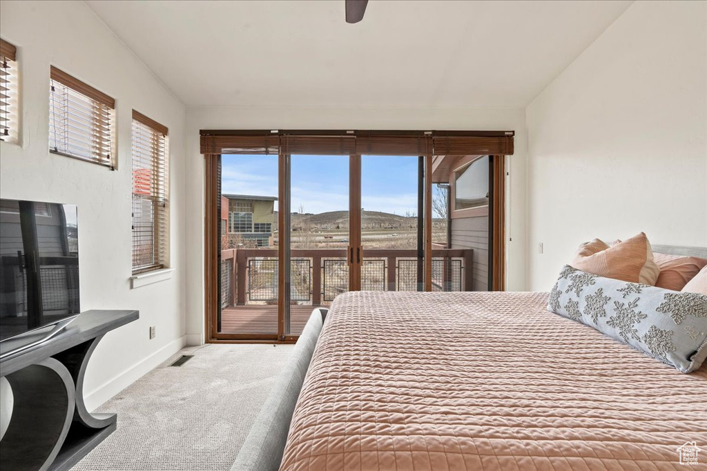 Bedroom with access to exterior, light colored carpet, and ceiling fan