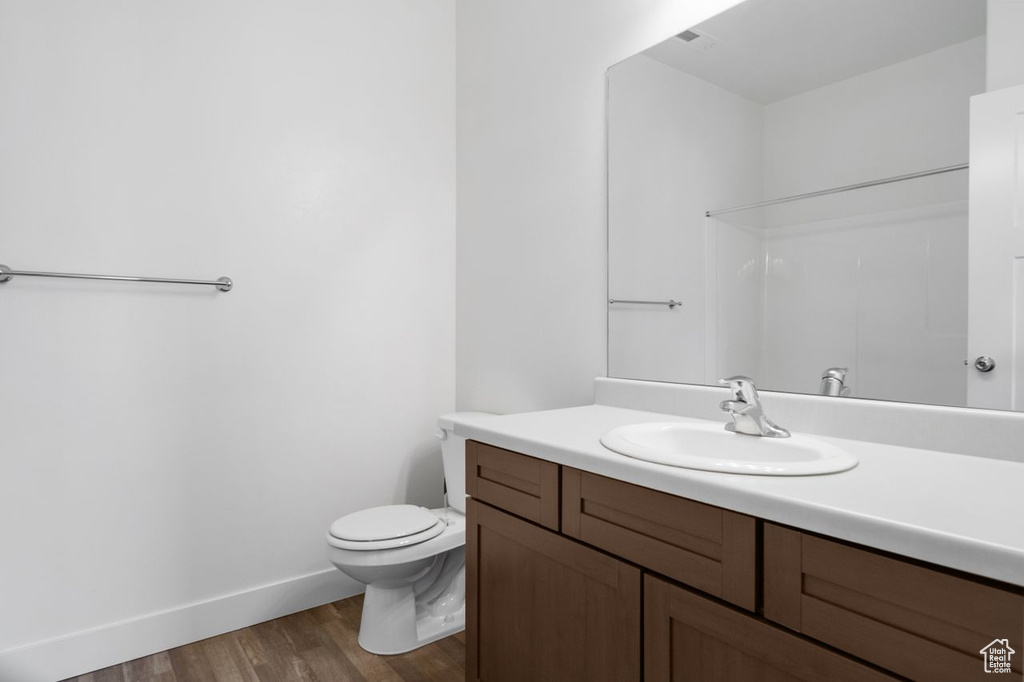 Bathroom featuring vanity, wood-type flooring, and toilet