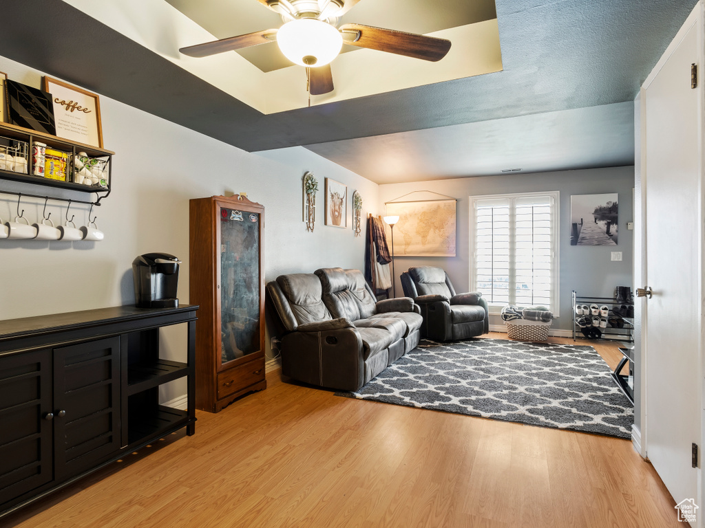 Living room with ceiling fan and light wood-type flooring