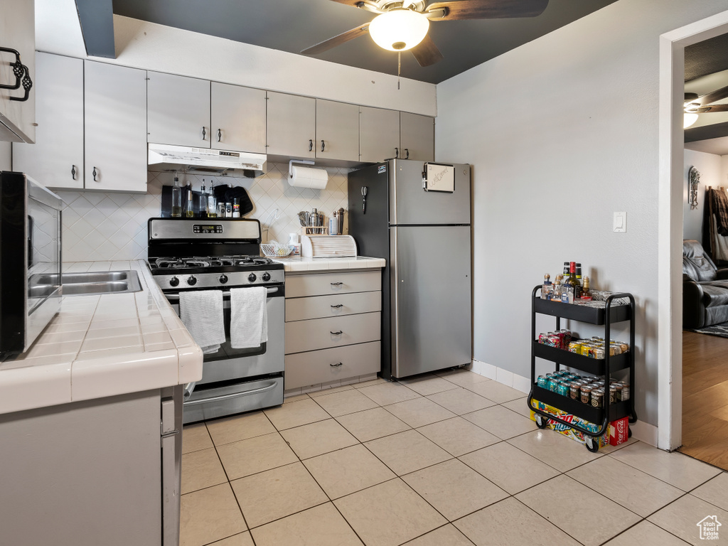 Kitchen featuring tasteful backsplash, stainless steel appliances, and ceiling fan