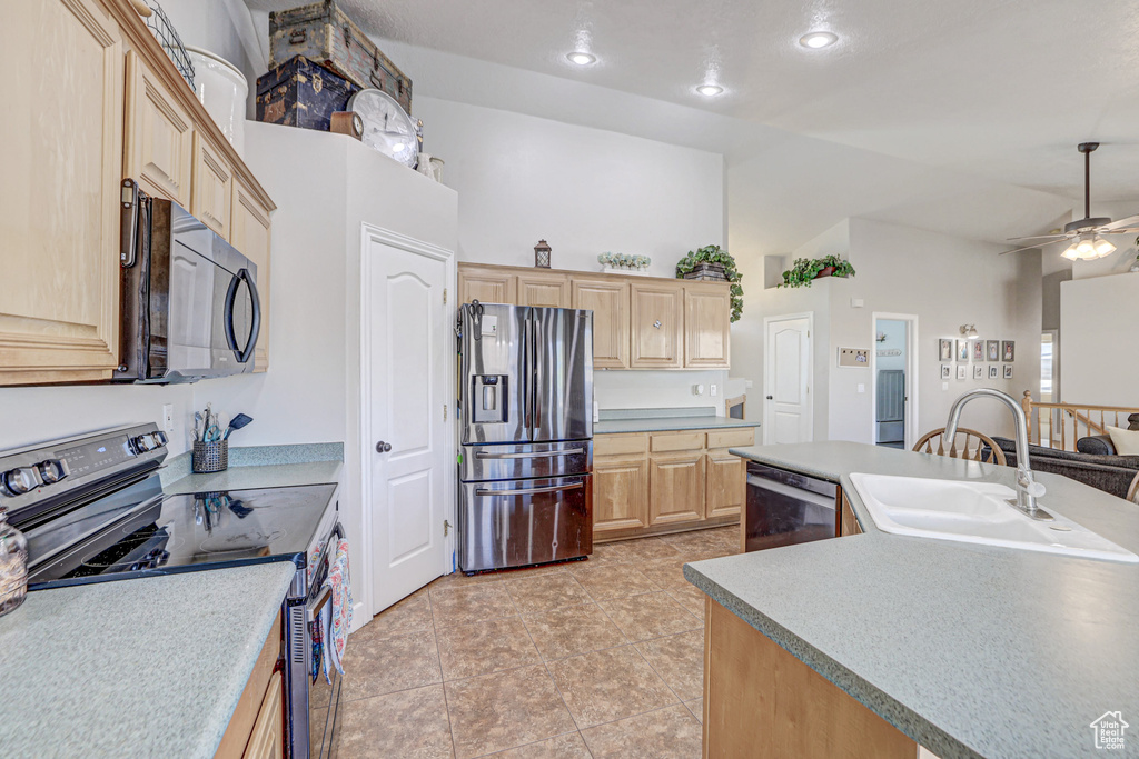 Kitchen featuring light brown cabinets, light tile floors, stainless steel appliances, ceiling fan, and sink