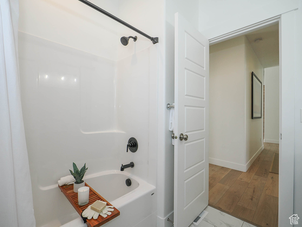 Bathroom featuring hardwood / wood-style floors and shower / tub combo