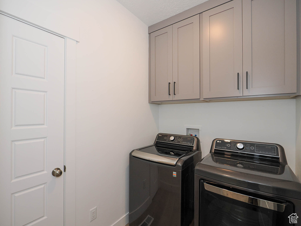 Laundry room with washer hookup, washing machine and dryer, and cabinets