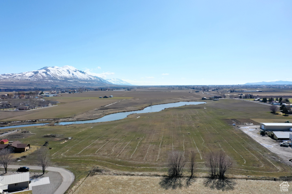 Drone / aerial view with a water and mountain view and a rural view