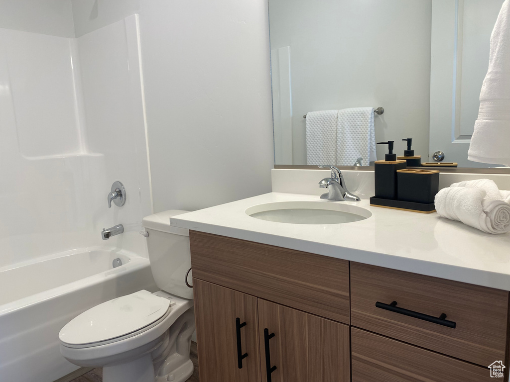 Full bathroom featuring toilet, vanity, and tub / shower combination