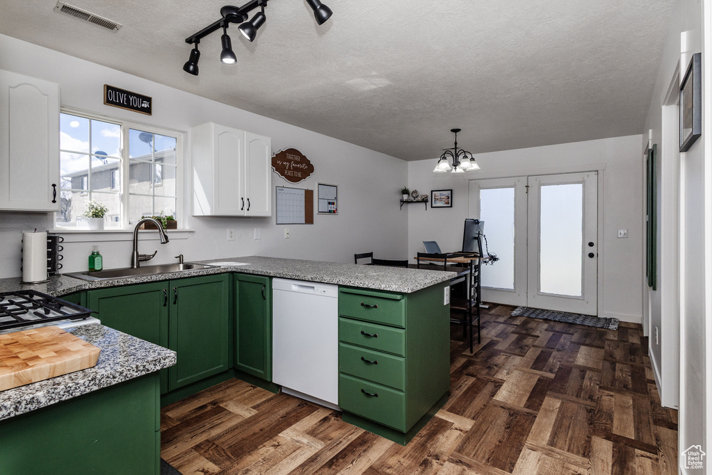 Kitchen with green cabinetry, white dishwasher, dark parquet flooring, and white cabinets