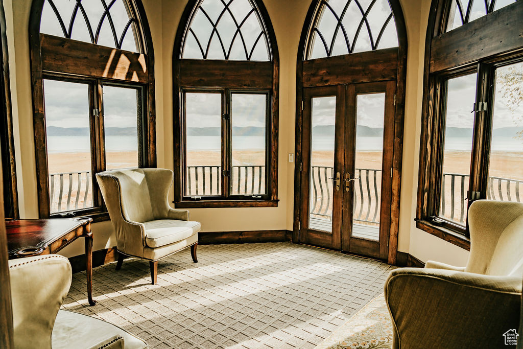 Sunroom featuring french doors, a healthy amount of sunlight, and a water view
