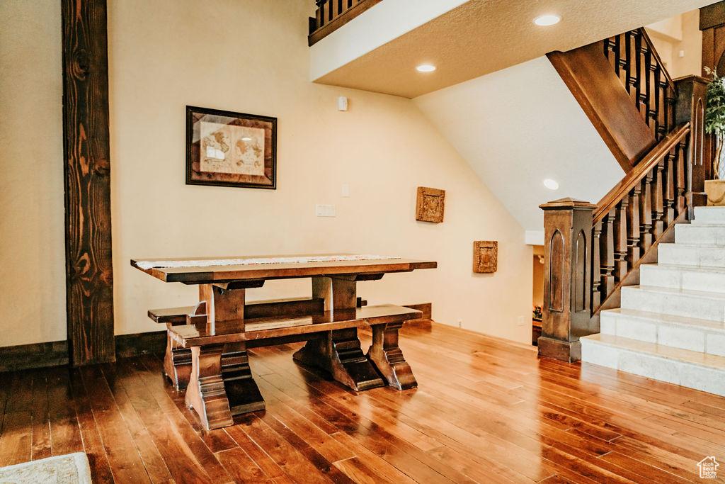 Dining room with high vaulted ceiling and hardwood / wood-style flooring