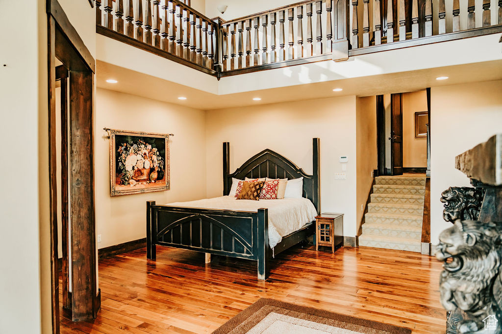 Bedroom featuring hardwood / wood-style floors and a high ceiling
