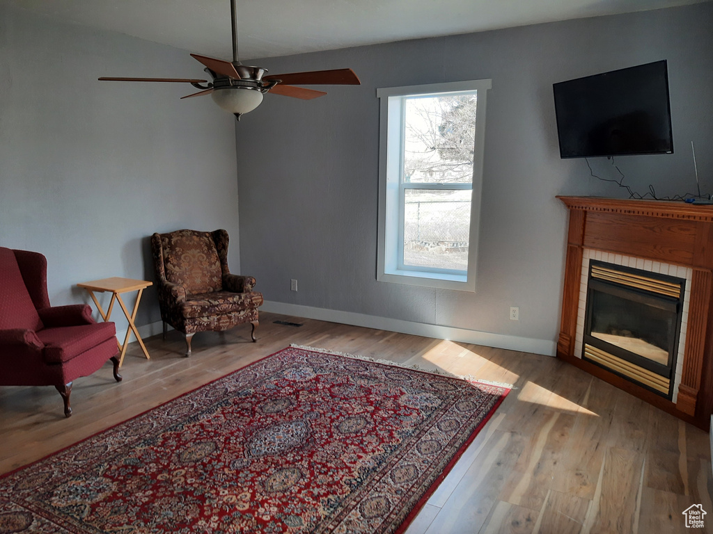 Sitting room with lofted ceiling, ceiling fan, and light wood-type flooring