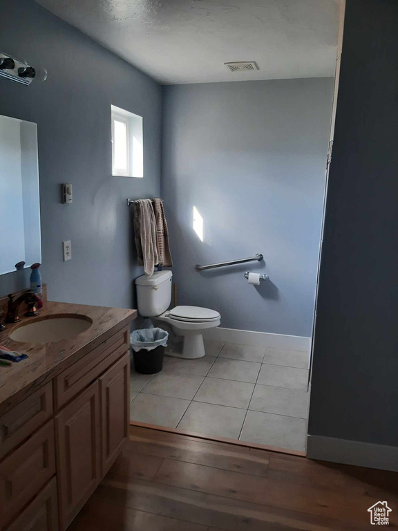 Bathroom with toilet, tile flooring, and vanity