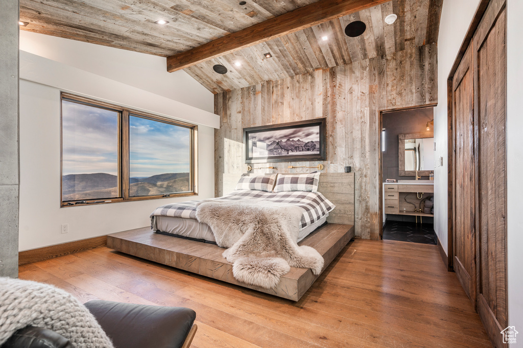 Bedroom with lofted ceiling with beams, wooden ceiling, and light hardwood / wood-style flooring