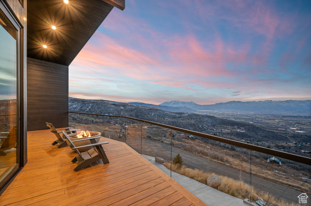 Deck at dusk with a fire pit and a mountain view