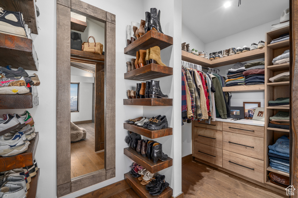 Spacious closet featuring dark hardwood / wood-style floors and vaulted ceiling