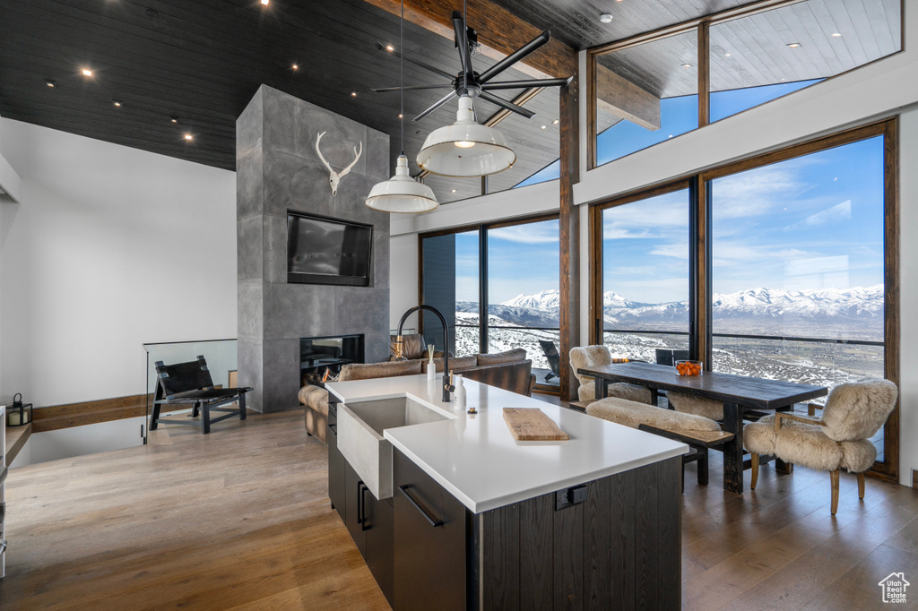 Kitchen with dark hardwood / wood-style flooring, a tile fireplace, a center island with sink, and a mountain view