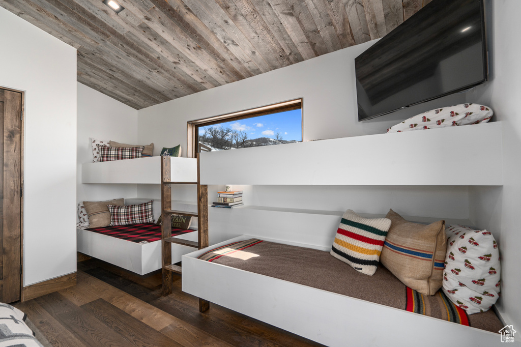 Bedroom with wood ceiling and dark hardwood / wood-style floors