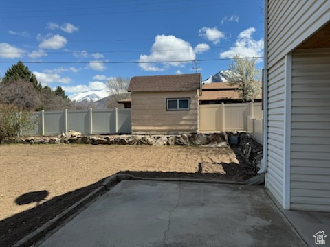 View of yard with a storage shed and a patio