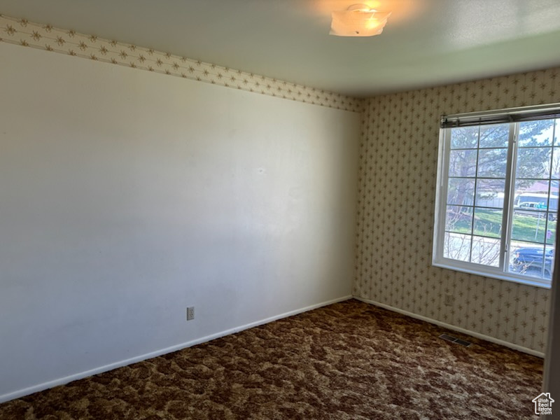 Empty room featuring dark carpet