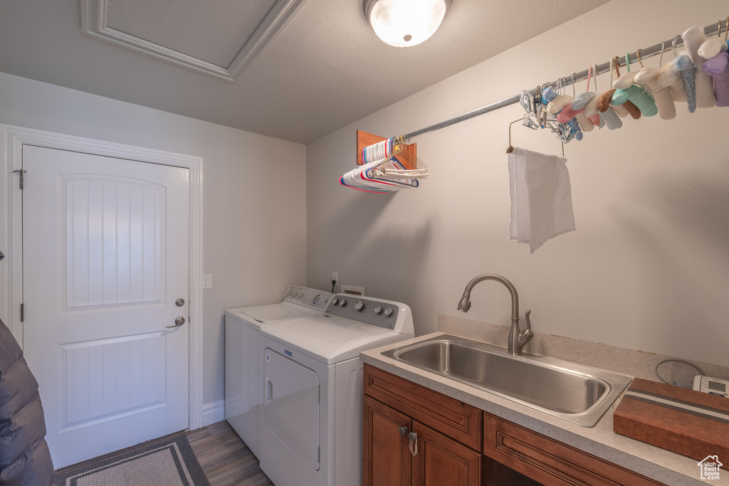 Laundry room featuring sink, cabinets, washer and clothes dryer, dark hardwood / wood-style floors, and hookup for a washing machine