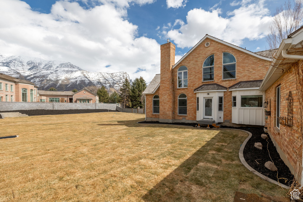 Back of house featuring a lawn and a mountain view