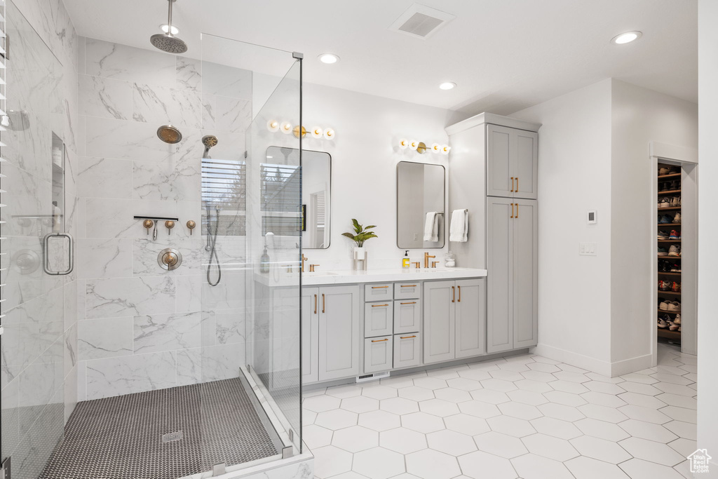 Bathroom featuring double sink vanity, tile flooring, and walk in shower