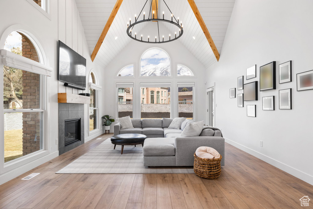 Living room featuring light hardwood / wood-style flooring, a wealth of natural light, and high vaulted ceiling