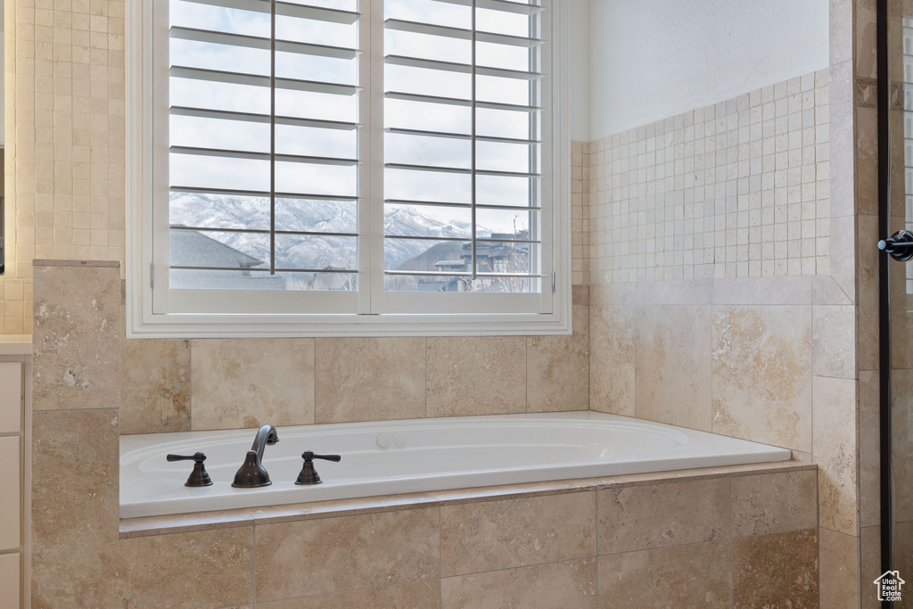 Bathroom with a relaxing tiled bath and a mountain view