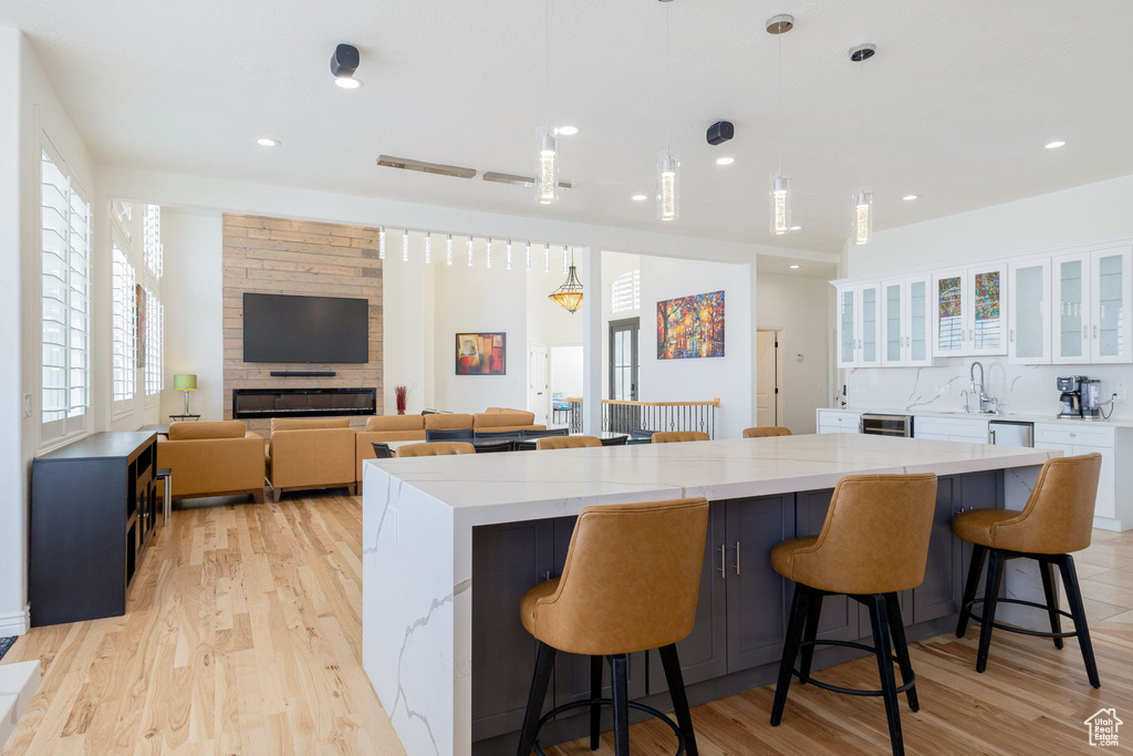 Kitchen with a breakfast bar area, white cabinetry, and light hardwood / wood-style floors