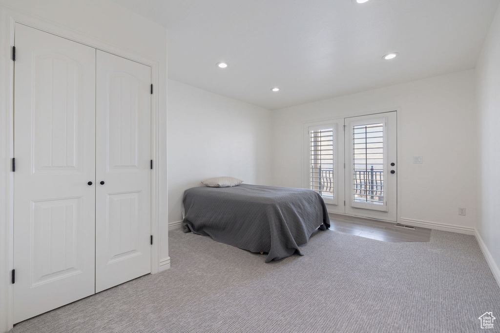 Carpeted bedroom featuring a closet and access to outside