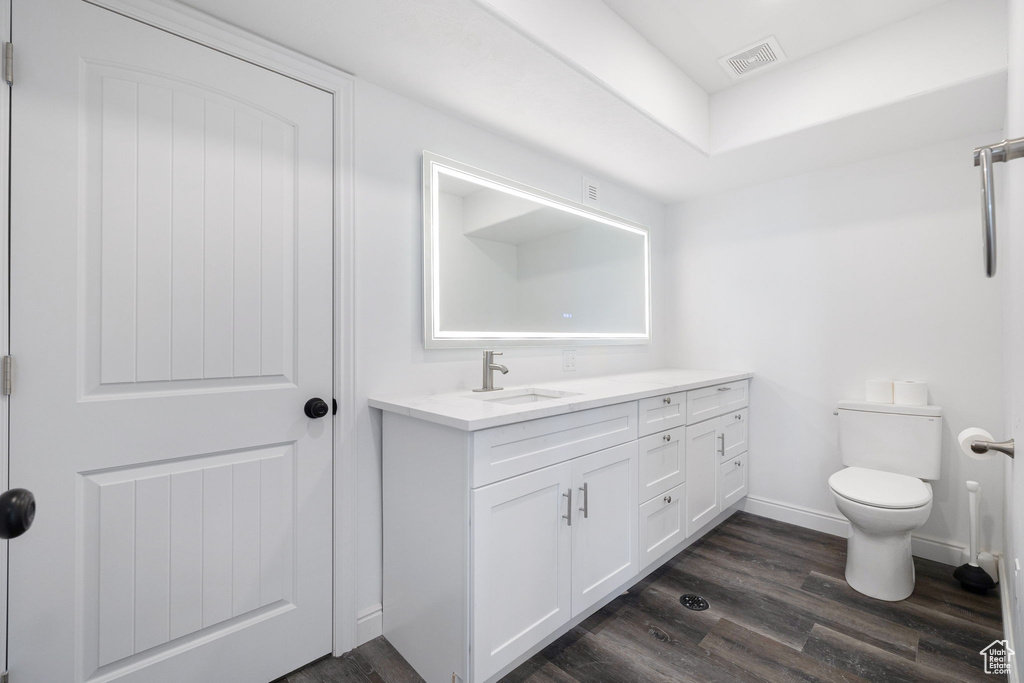 Bathroom with toilet, wood-type flooring, and vanity