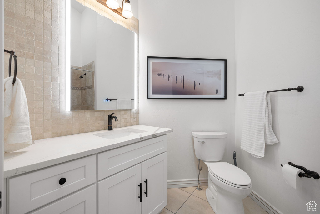 Bathroom with vanity, tile flooring, tasteful backsplash, and toilet